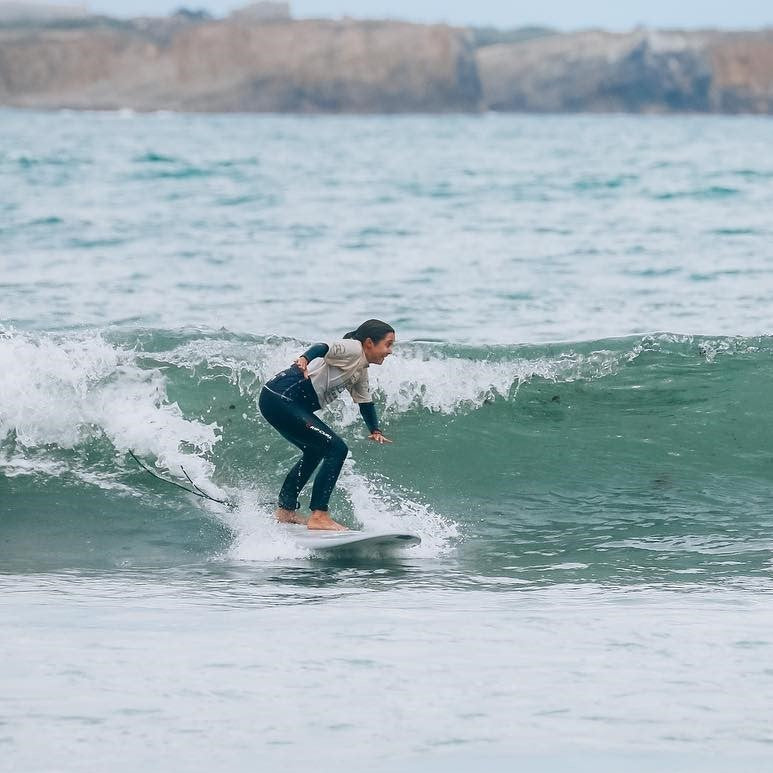 Mujer surfeando ola pequeña con tabla evolutiva en el mar, entorno natural