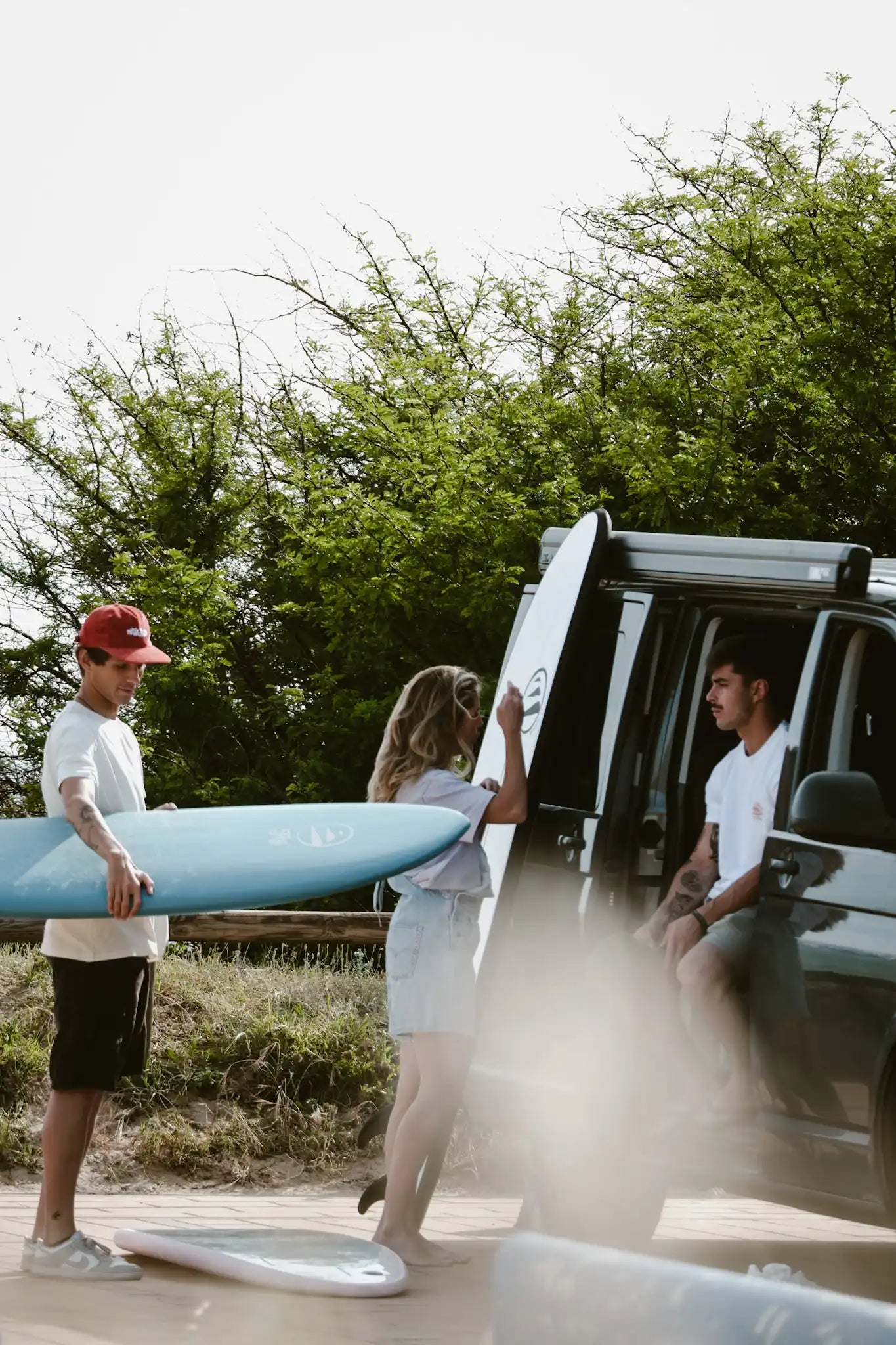 3 personas con sus tablas de flysurf en una furgoneta en costa rica