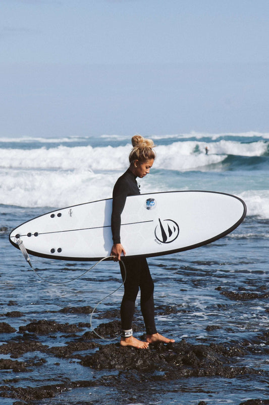 influencer andando por la playa con tabla de surf dharma de flysurf