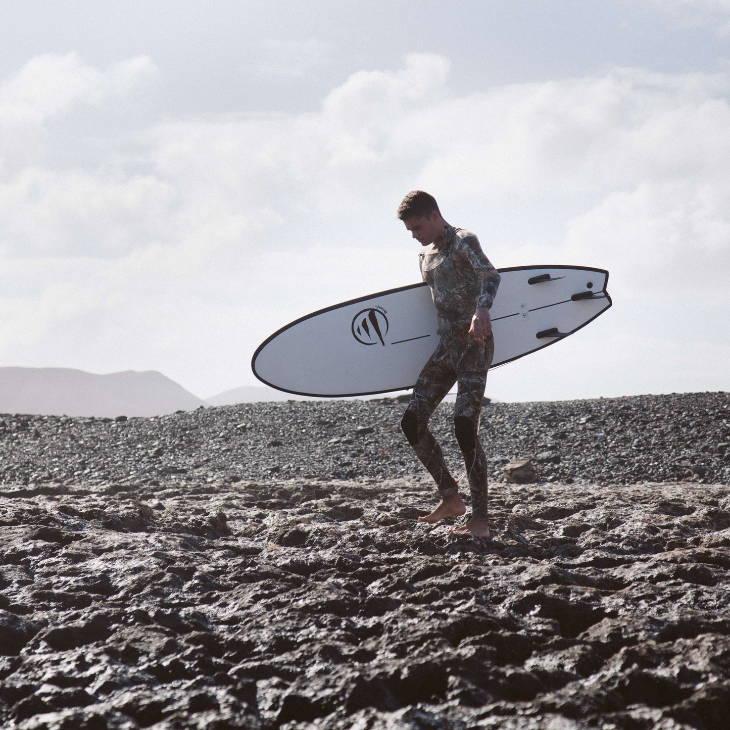 influencer andando por la playa con la tabla de surf evolutiva the traveller