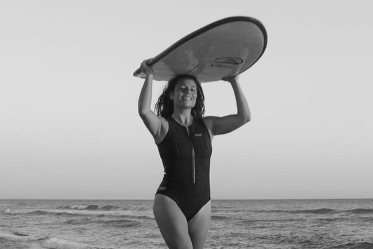 Chica mostrando la tabla de surf de iniciación que ha elegido