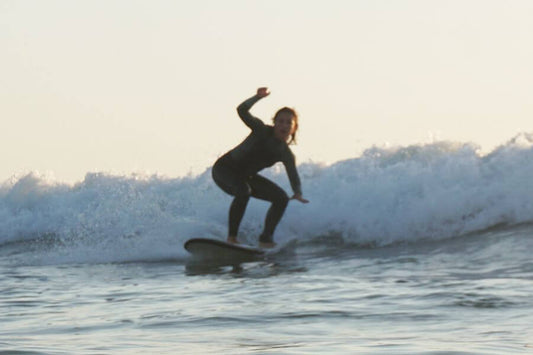 Persona poniendose de pie en tabla de surf siguiendo los mejores tips para progresar en surf