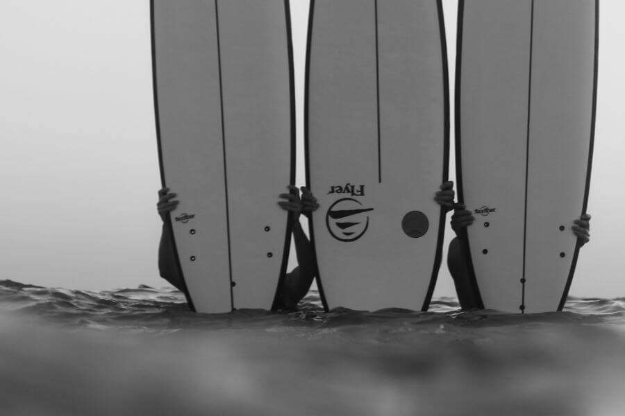 3 chicos mostrando sus tablas en un surfcamp de flysurf