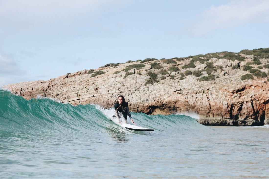 Mujer surfeando con tabla fly y usandoApps imprescindibles para surfistas principiantes