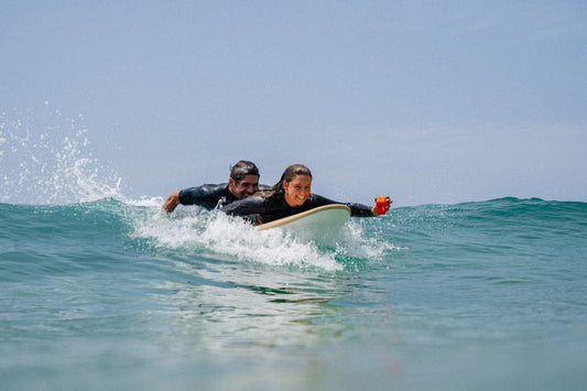 monitor de una de las Mejores escuelas de surf en España y Portugal ayudando a una alumna