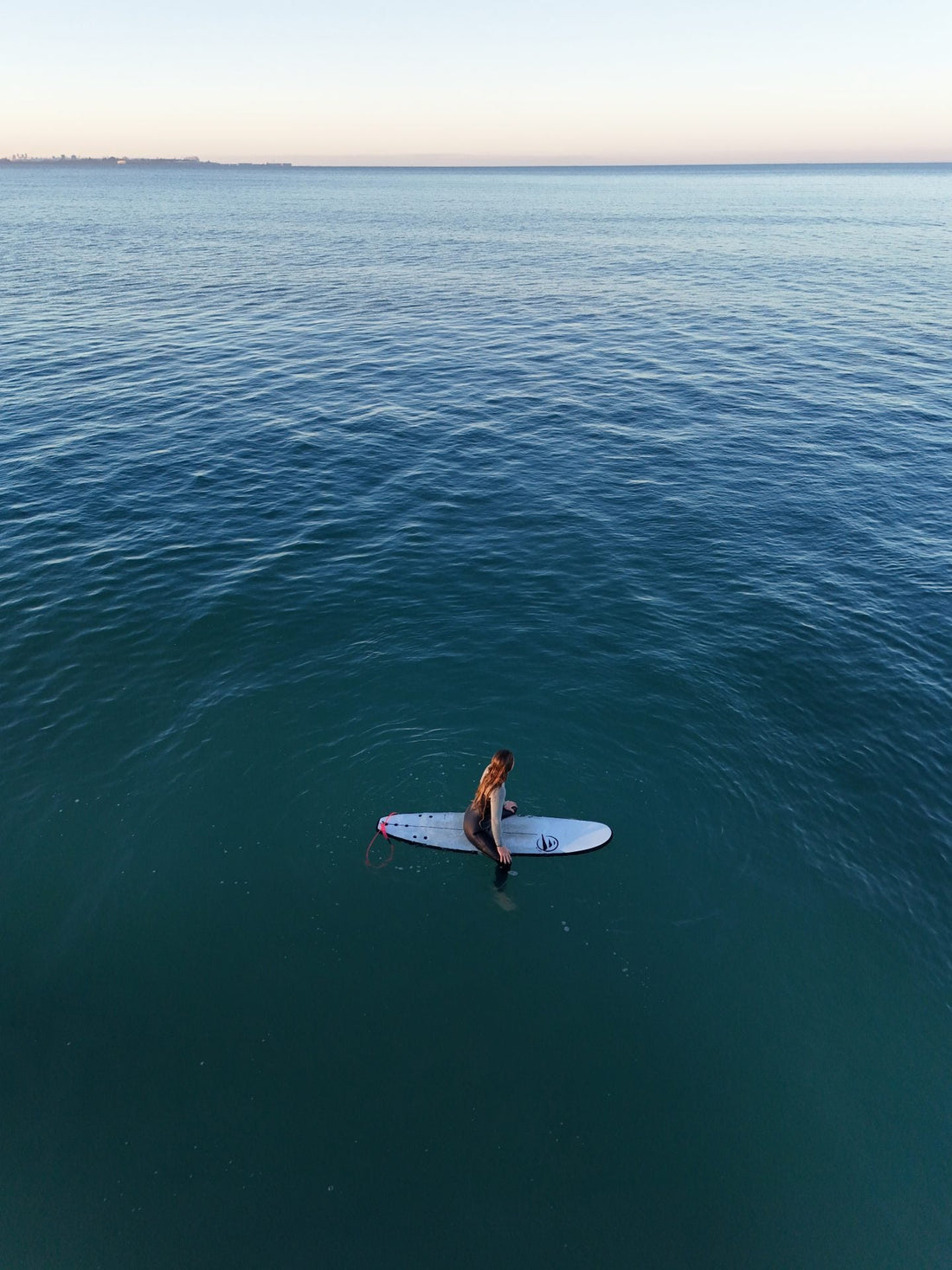 Surfista siguiendo tips de surf para principiantes en aguas tranquilas y practicando yoga sobre la tabla