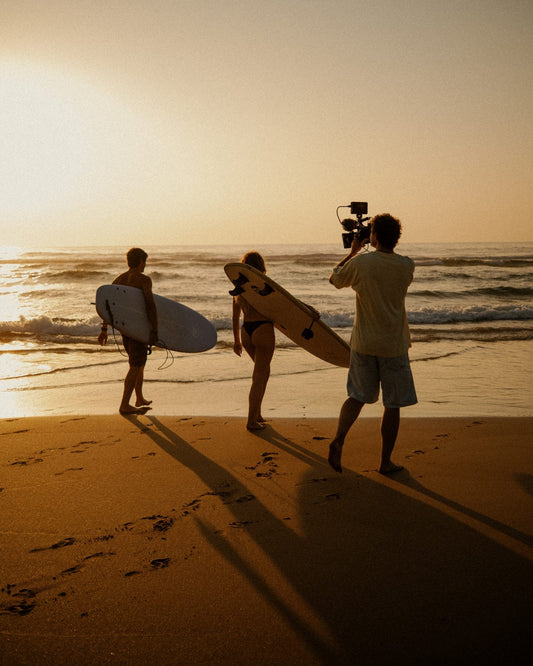 Surfistas caminando hacia el mar al atardecer durante un surftrip