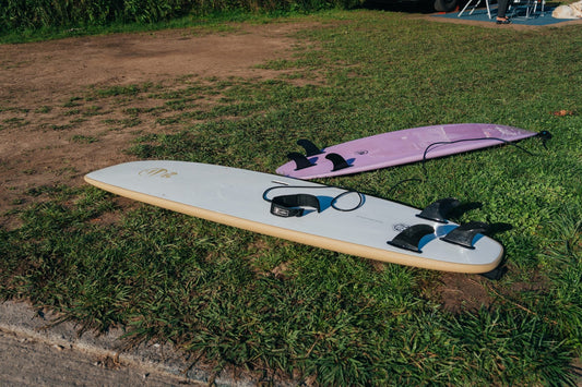 Dos tablas de surf, una softboard y otra de fibra, mostrando la diferencia entre una ambas.
