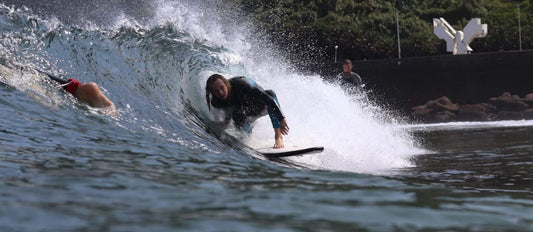 Persona cogiendo un tubo de surf con una tabla flysurf