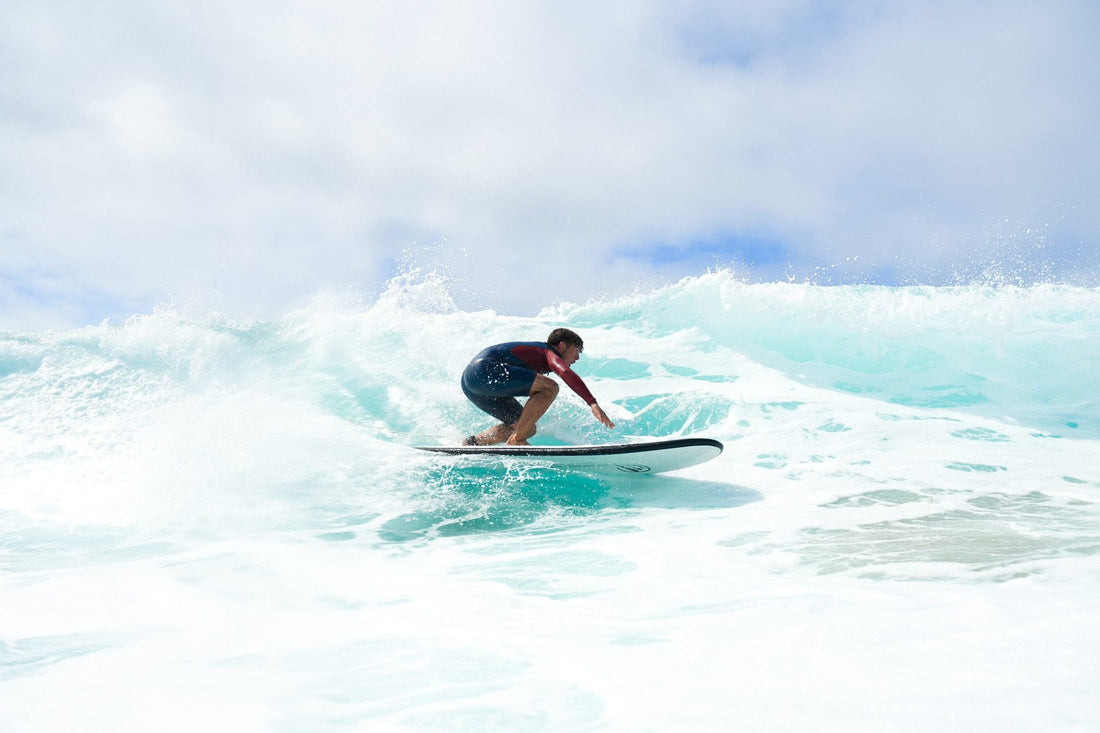 Surfista haciendo trucos y maniobras en la ola