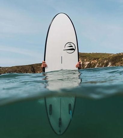 tabla de surf en el mar con el logo de Flysurf y de la marca Flysurf