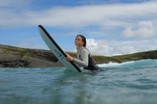 Chica haciendo surf en las mejores playas para surfear en Murcia