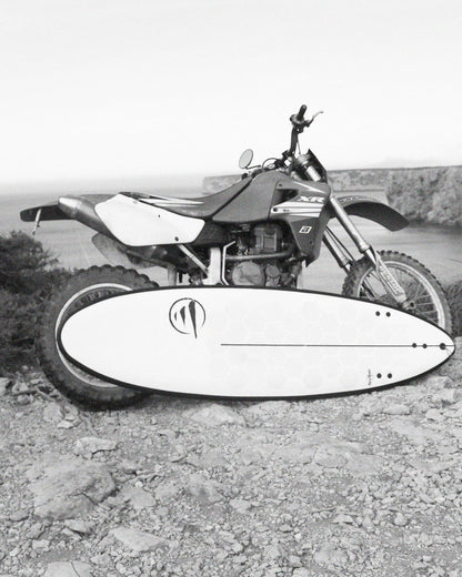 Tabla Dharma FCS 6.2 apoyada en una moto