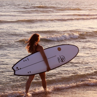 Mujer influencer en la playa con una tabla The Traveller 6.6