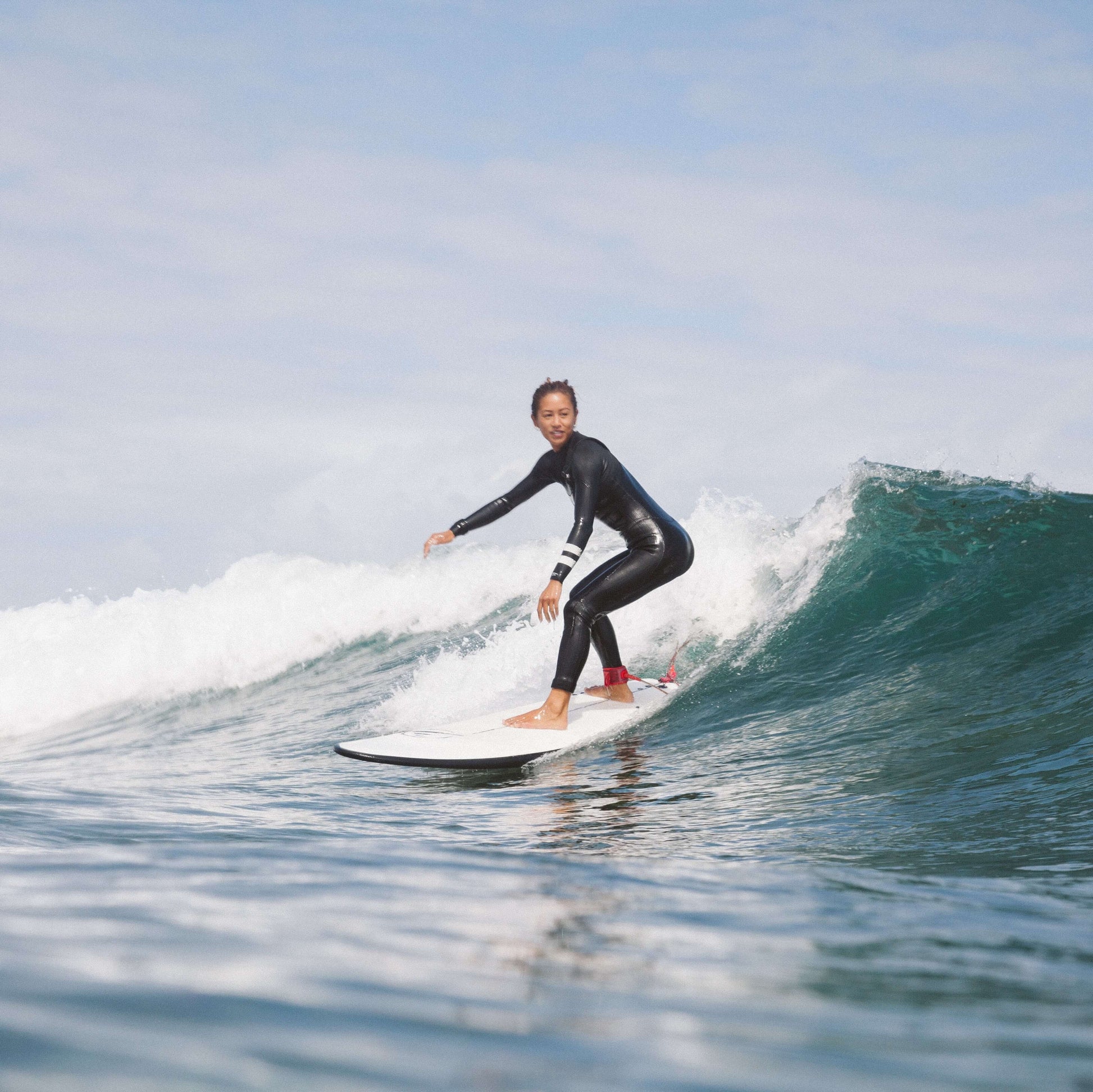 Donna surfista che surfa un&#39;onda con una planche évolutive Flysurf