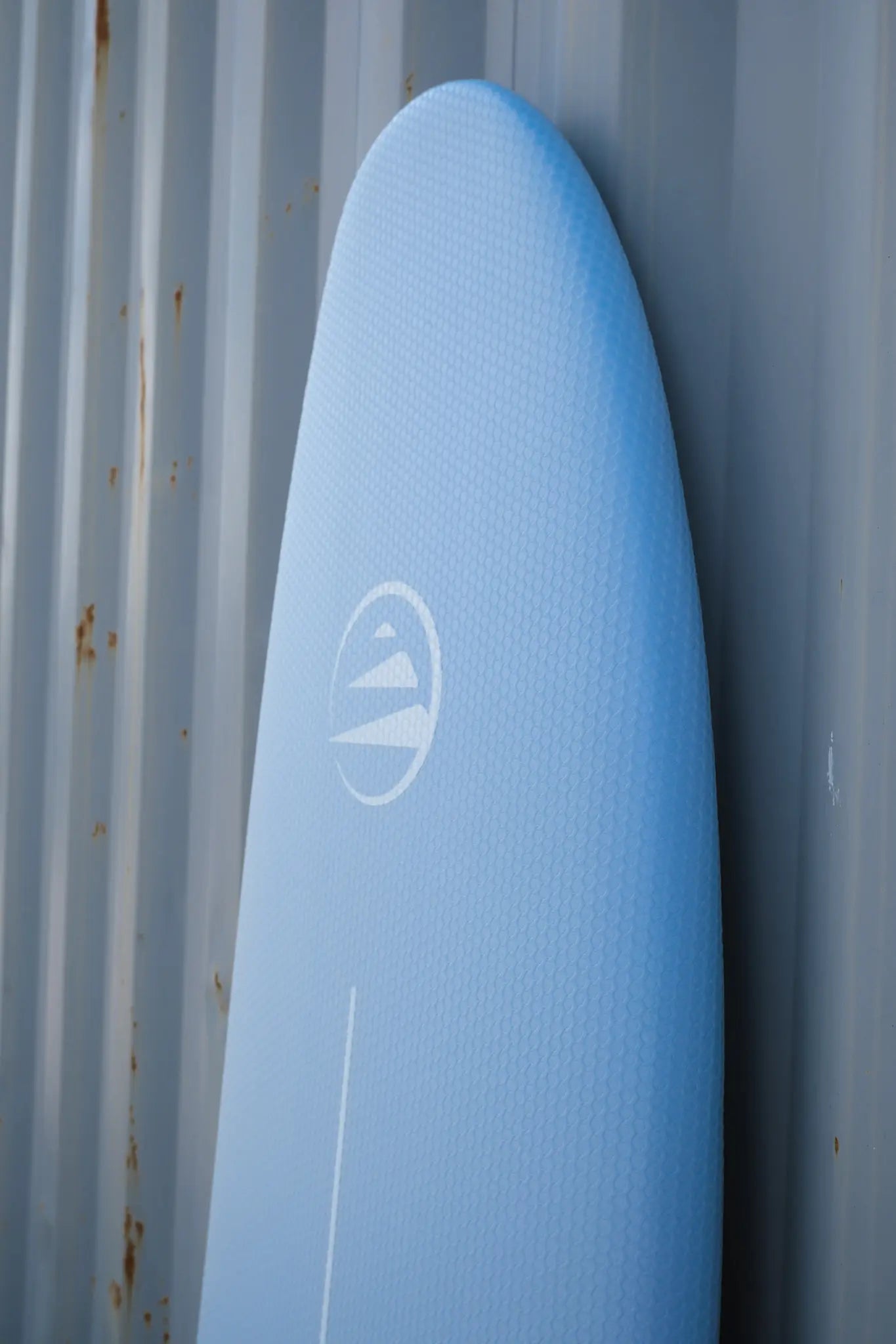 Detalle del nose de la tabla de surf azul de corcho para principiantes.
