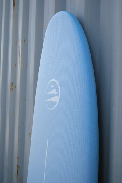 Detalle del nose de la tabla de surf azul de corcho para principiantes.