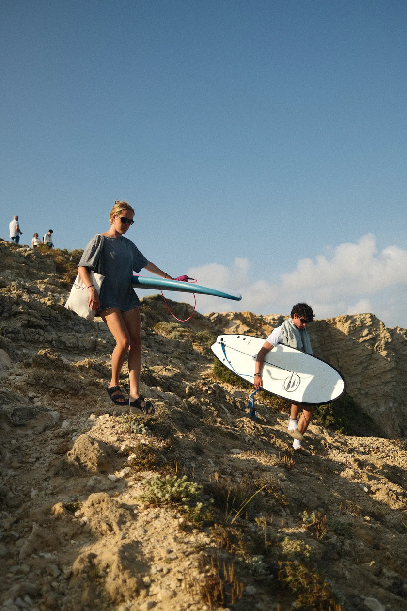 Bajando con las tablas de surf de flysurf por las rocas para ir a surfear. 