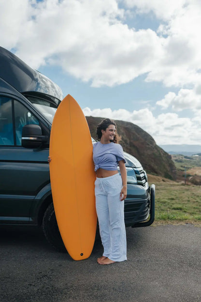 Chica con una furgoneta con una tabla de fibra naranja squash