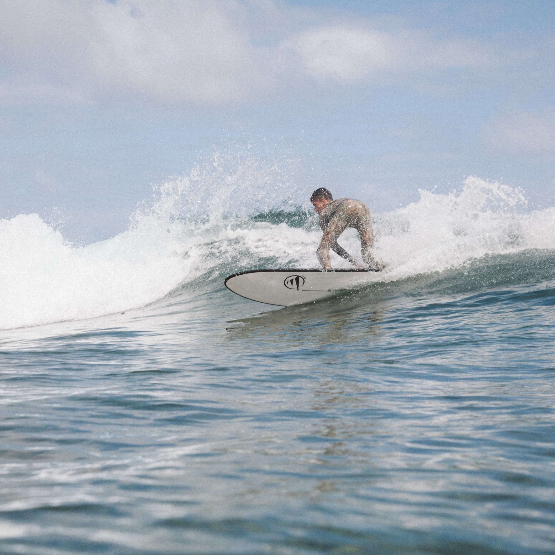 Influencer en la playa surfeado una ola con una tabla de surf Flysurf