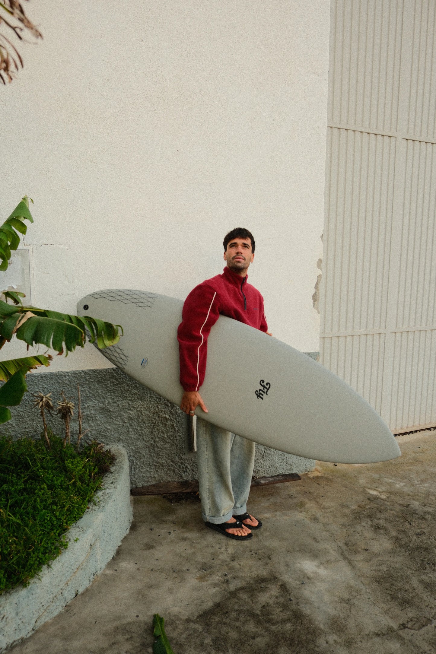 chico sosteniendo la tabla de surf apollo gris de fibra de flysurf