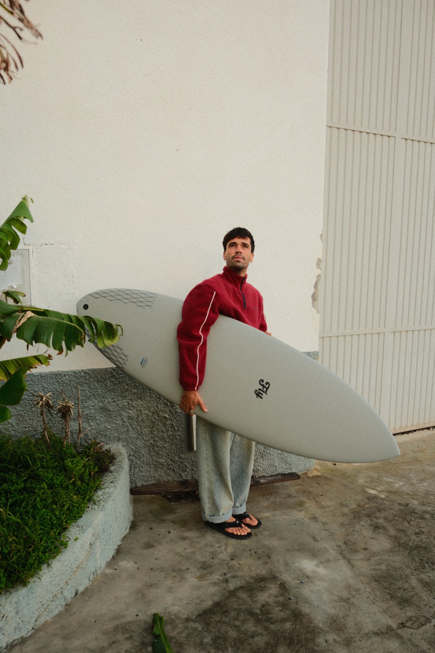 chico sosteniendo la tabla de surf apollo gris de fibra de flysurf