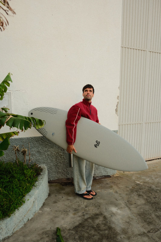chico sosteniendo la tabla de surf apollo gris de fibra de flysurf
