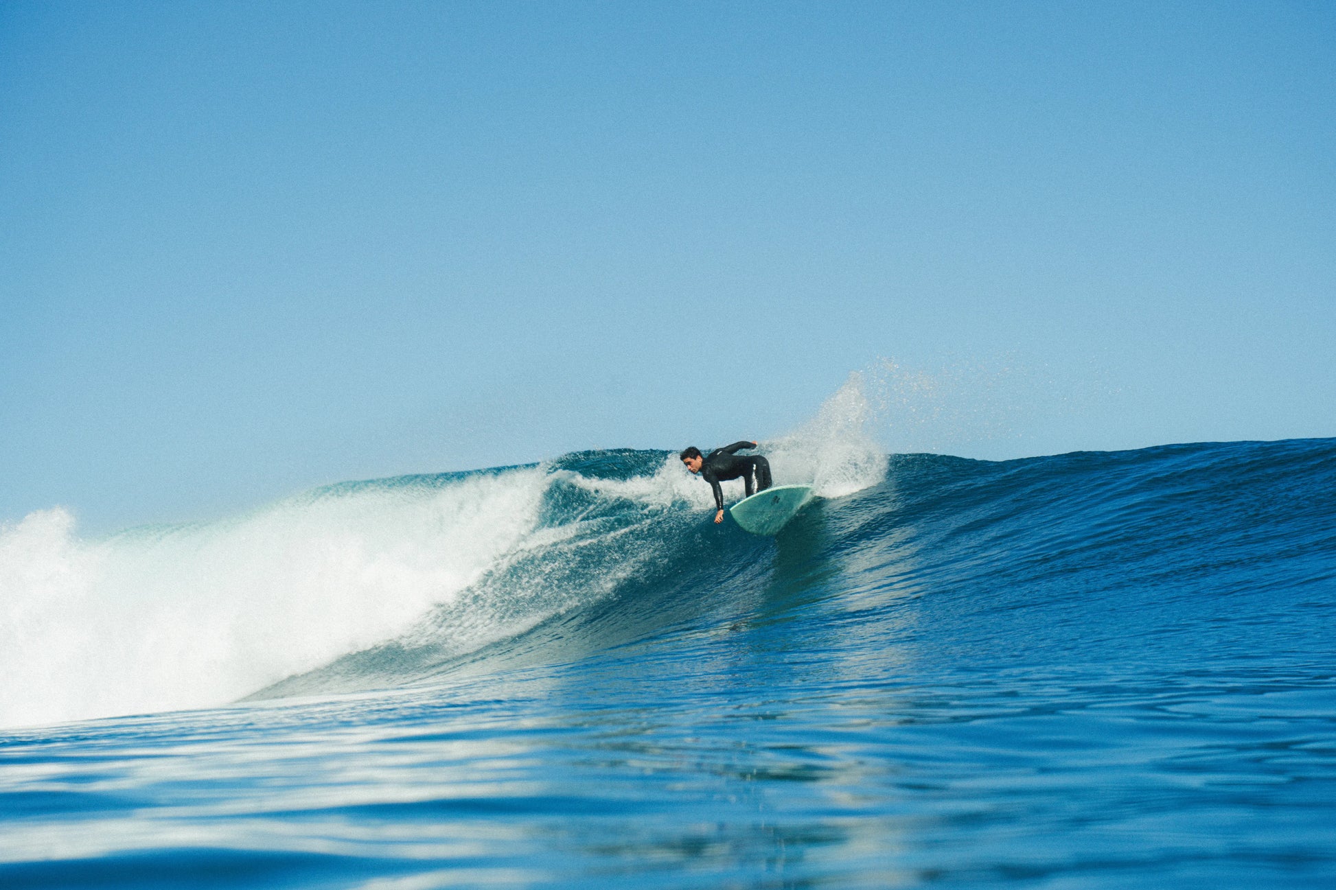 chico surfeando una gran ola y girando con su tabla de surf de fibra