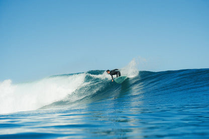 chico surfeando una gran ola y girando con su tabla de surf de fibra