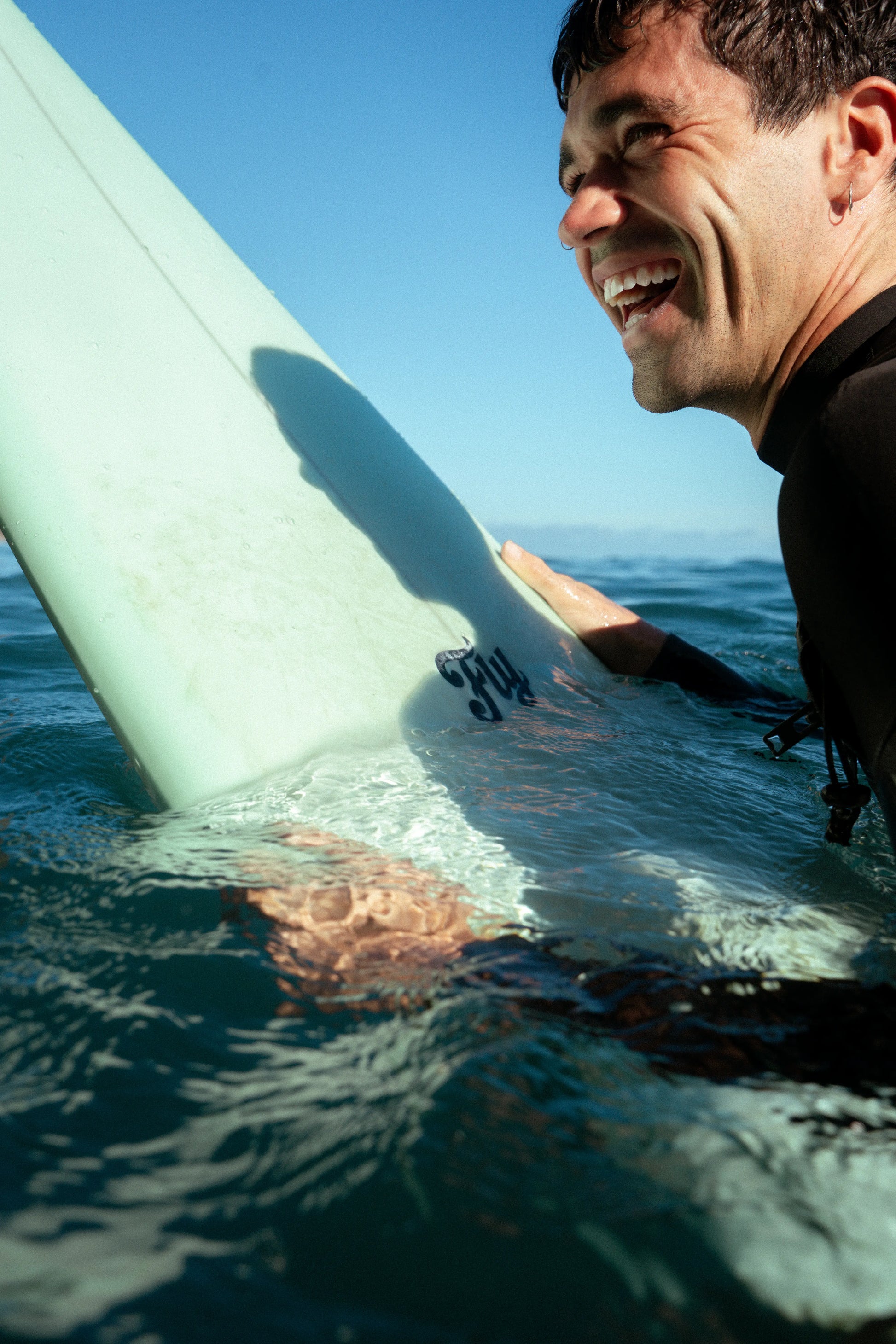 chico sonriendo con la nueva tabla de surf de flysurf apollo
