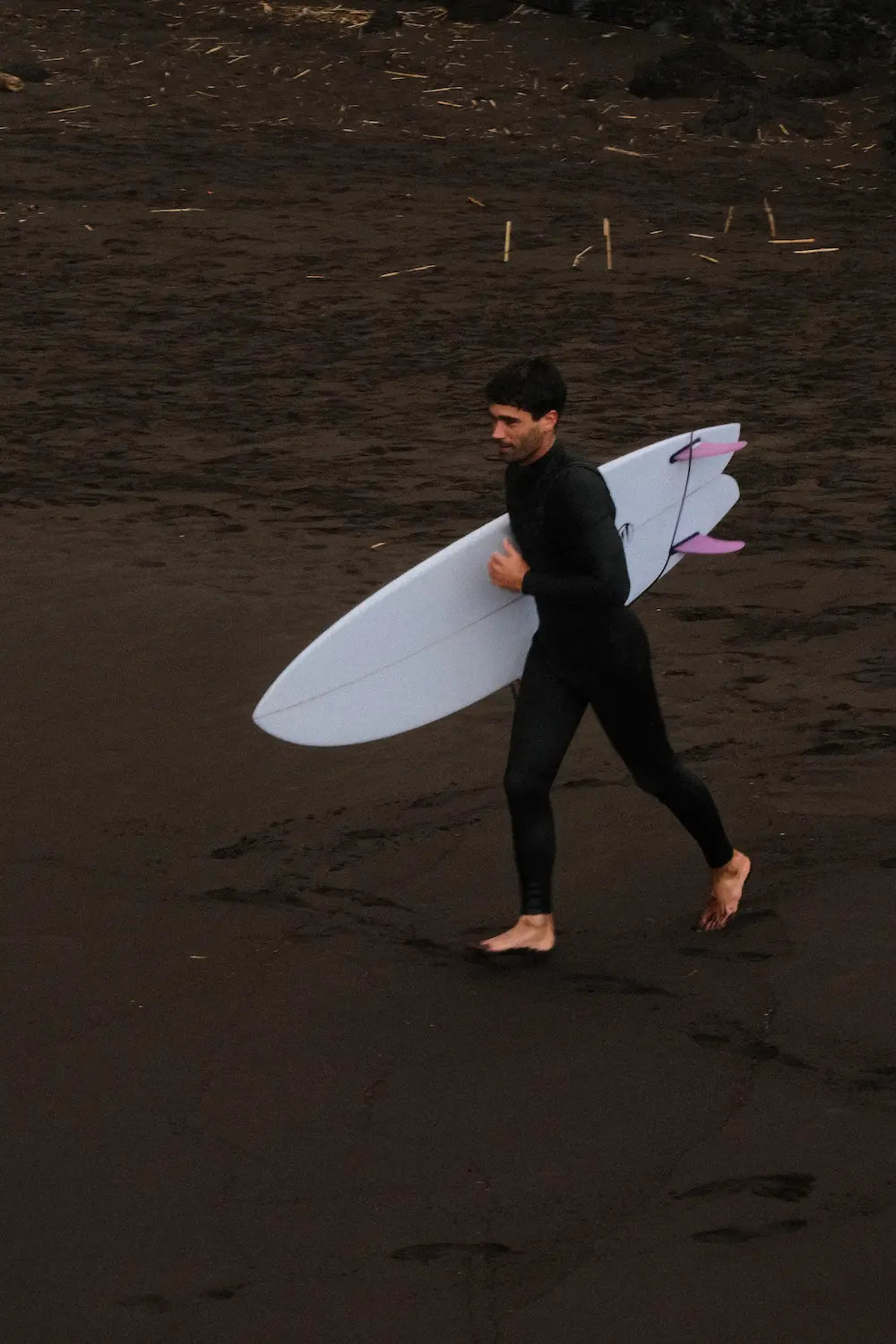 Alex yendo corriendo al agua para entrar a surfera con una tabla de surf fish blanca 6.4