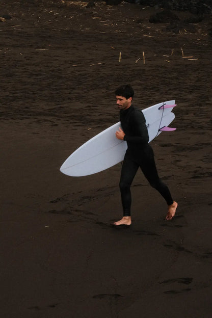 Alex yendo corriendo al agua para entrar a surfera con una tabla de surf fish blanca 6.4
