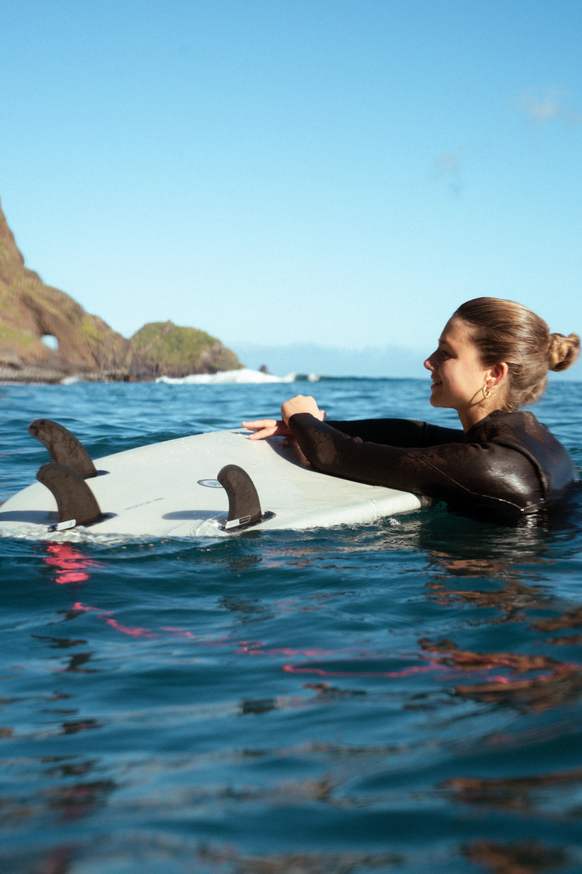chica en el agua con la tabla de surf apollo al revés