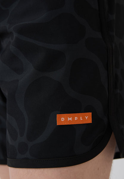 Detalle etiqueta naranja lateral bañador surf hombre Deeply Beach negro estampado