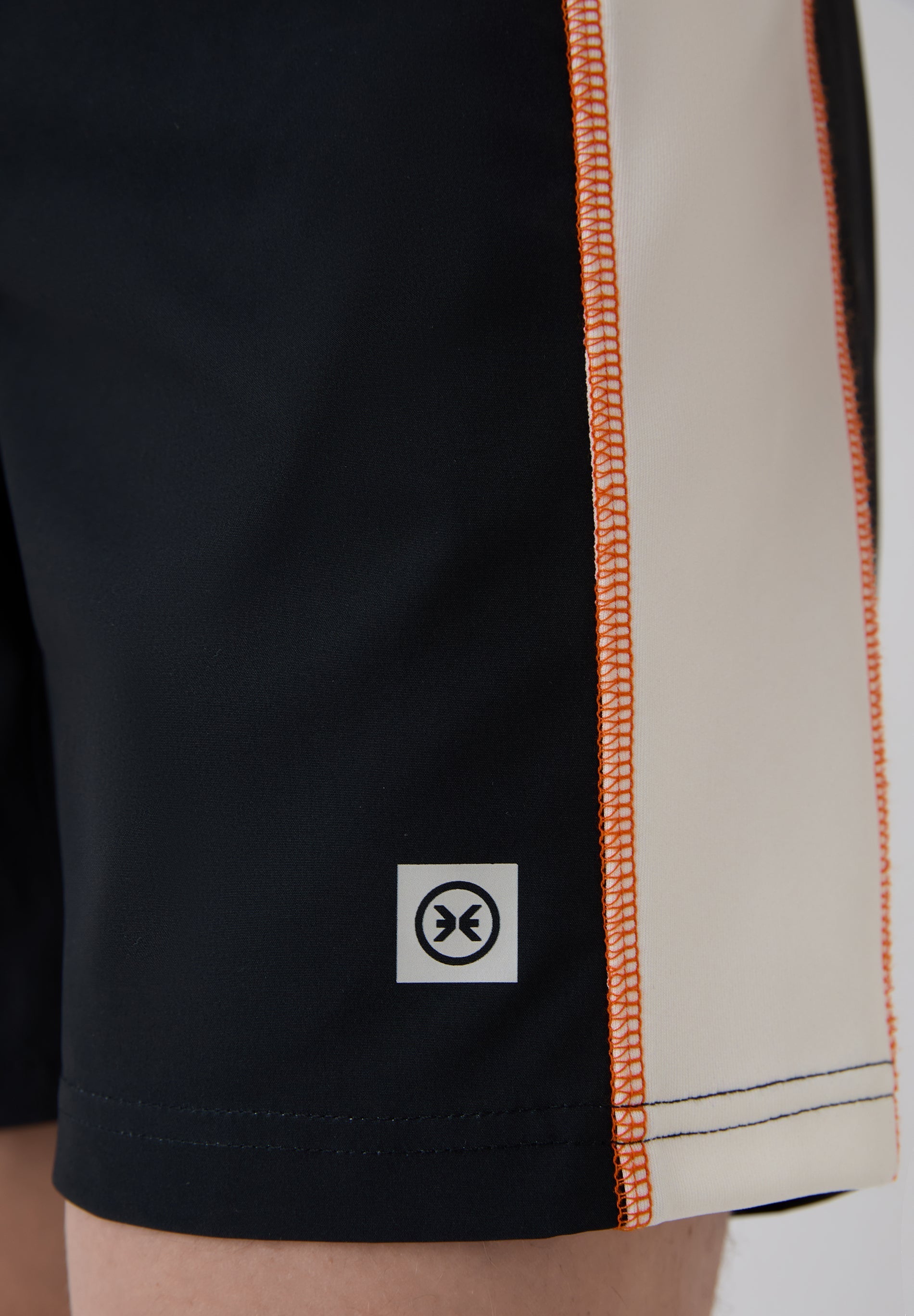 Detalle franja lateral blanca y logo bañador surf hombre Deeply Limitless II negro