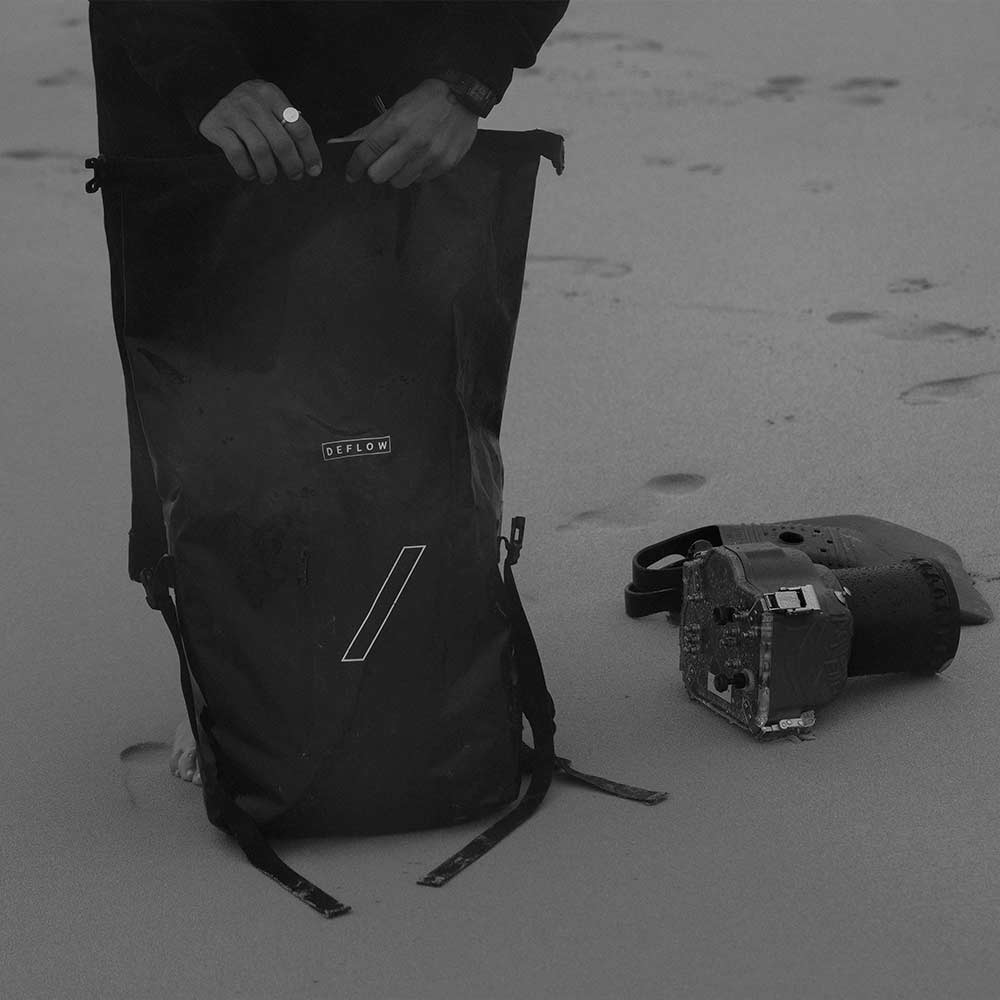 hombre cerrando la mochila estanca de deflow de 25 litros impermeable