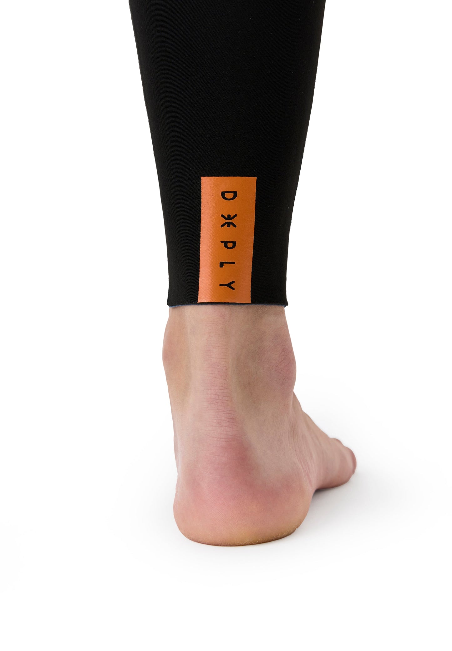 Acercamiento al acabado inferior de la pierna con ribete sellado y etiqueta distintiva de la marca en color naranja.