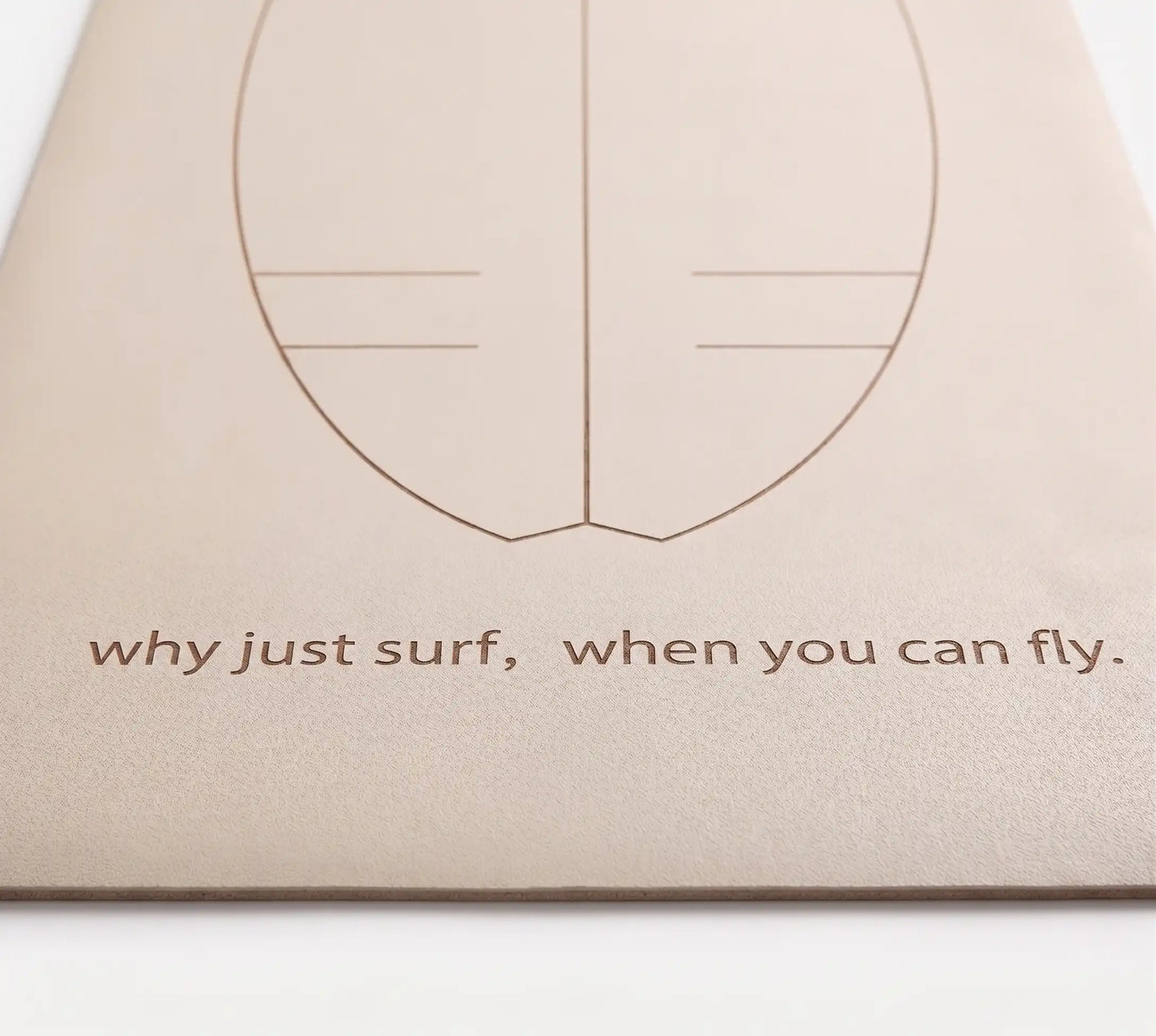 Detalle de la frase motivadora "Why just surf, when you can fly" grabada en la base de la esterilla