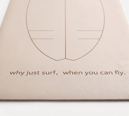 Detalle de la frase motivadora "Why just surf, when you can fly" grabada en la base de la esterilla