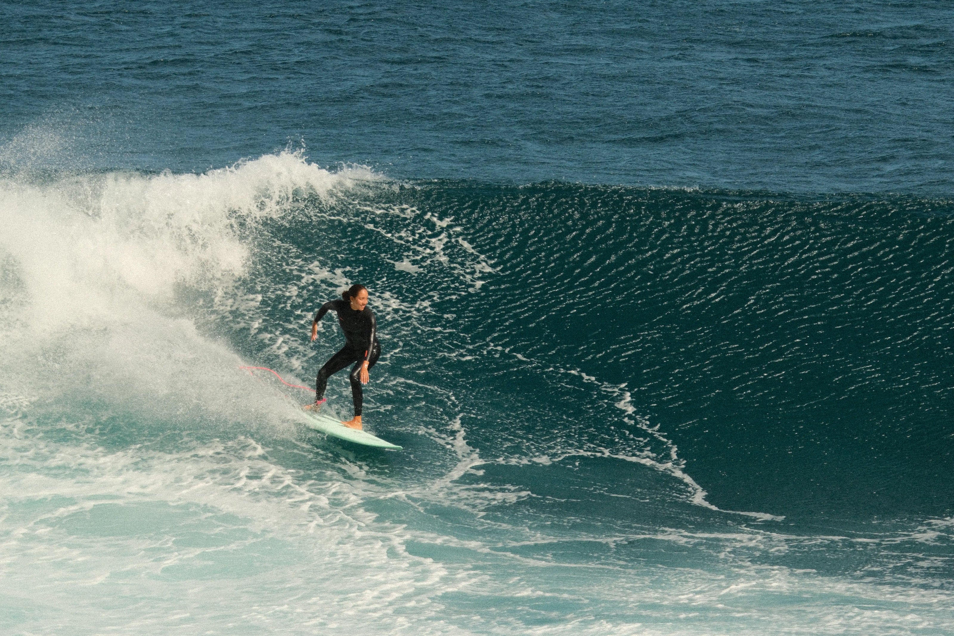 Un surfero del Fly Club deslizándose sobre una ola grande y verde