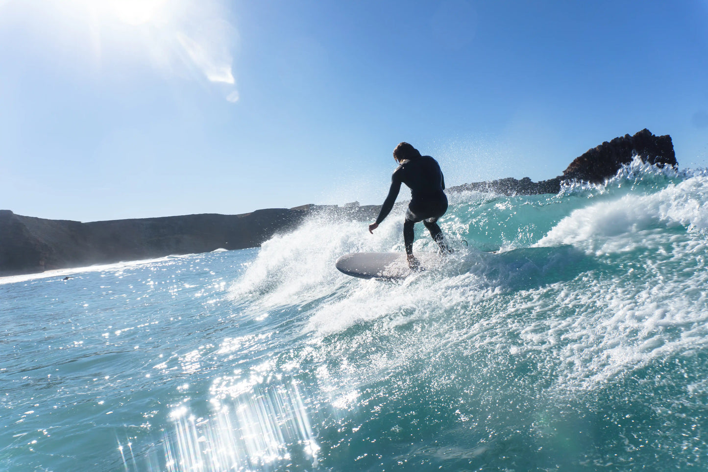Surfista realizando una maniobra sobre una ola con una tabla de surf epoxy de gran volumen (8.2 pies)