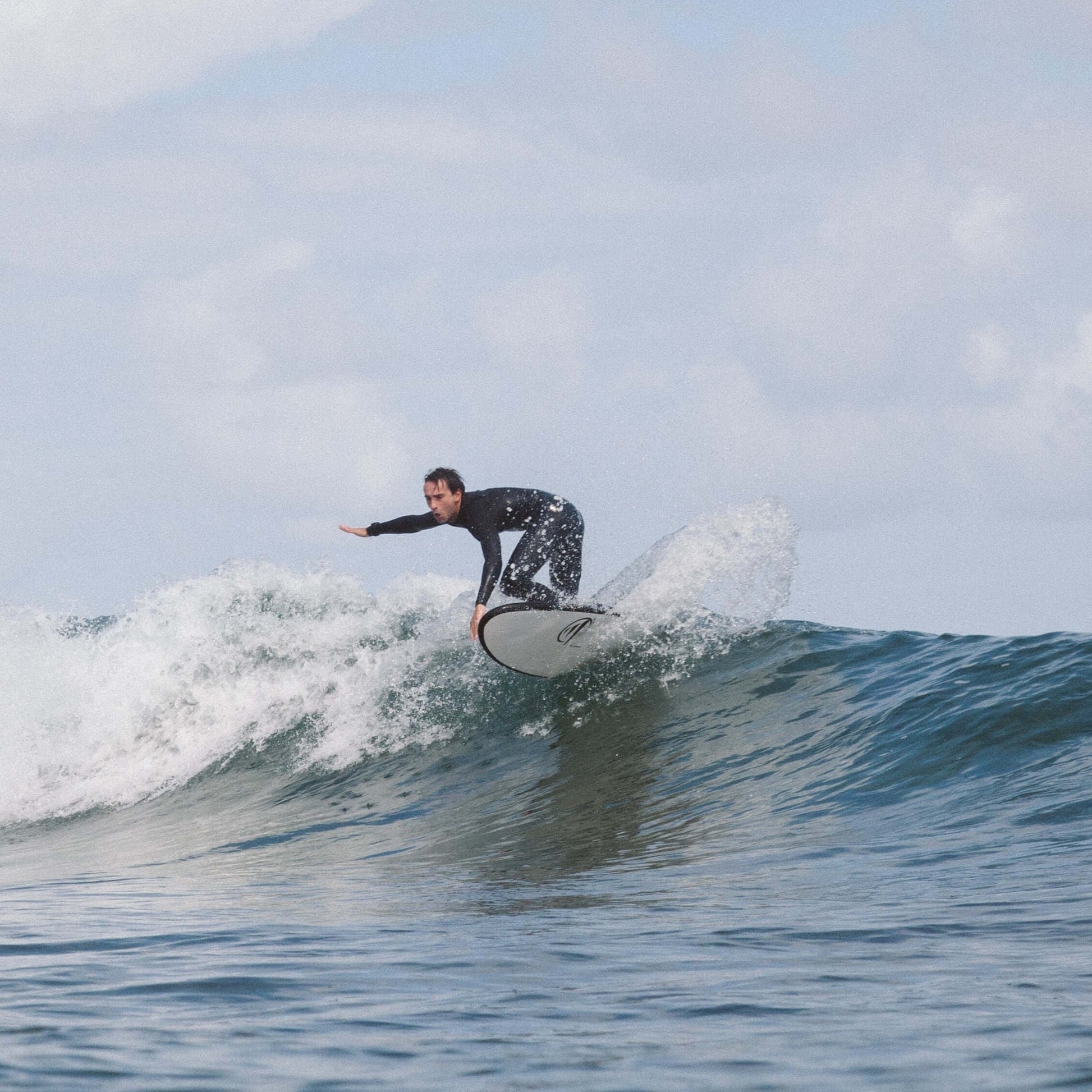 Influencer surft mit einem hybrid flysurf planche auf einer Welle