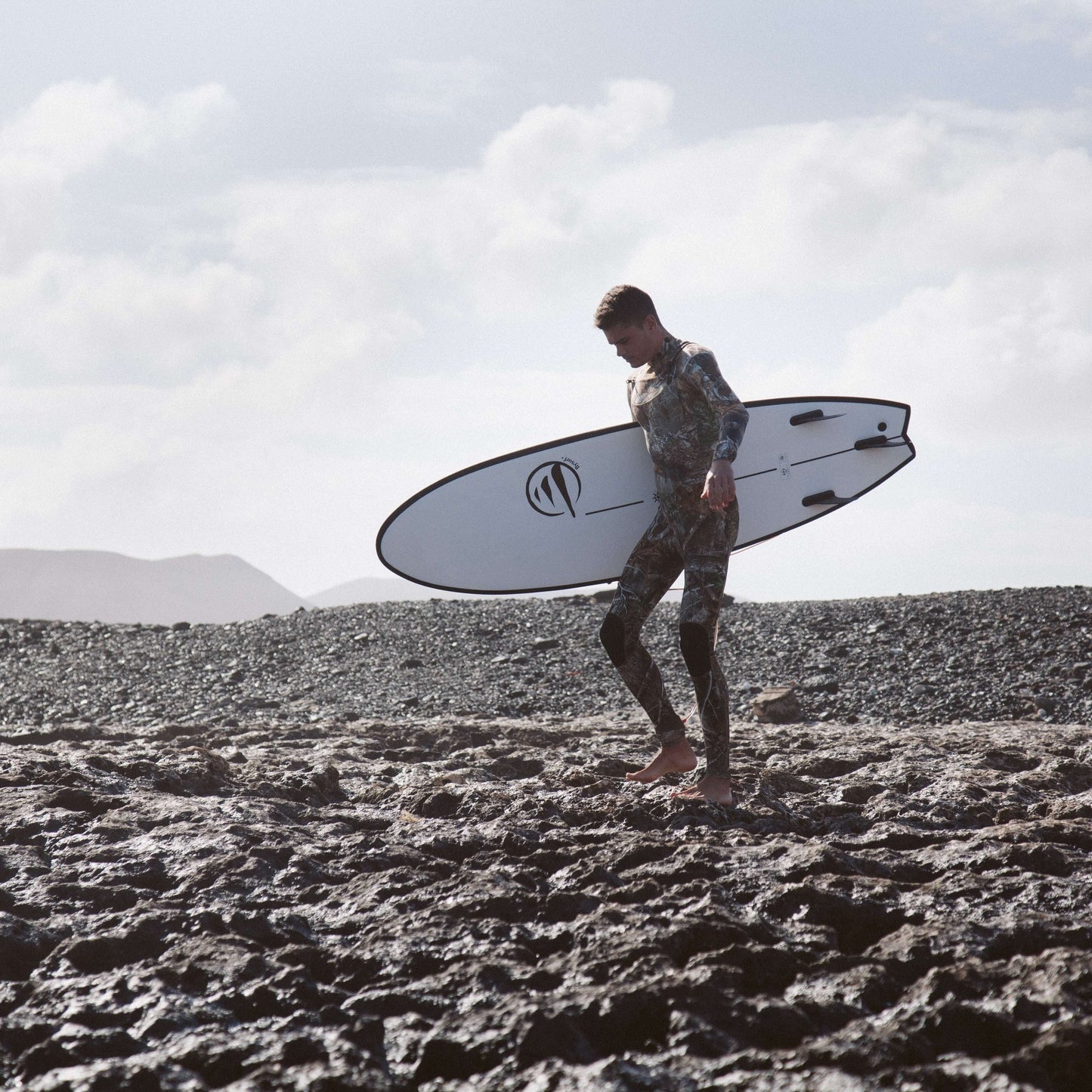 influencer andando por la playa con la tabla de surf evolutiva the traveller