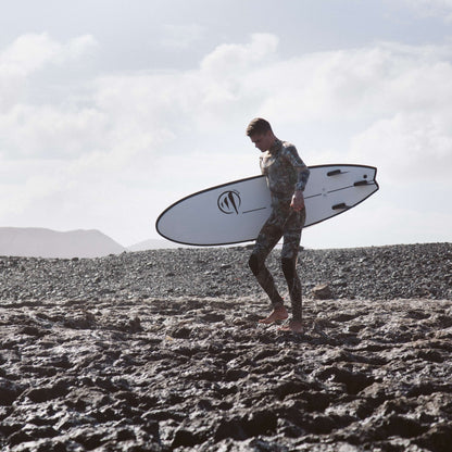 influencer andando por la playa con la tabla de surf evolutiva the traveller