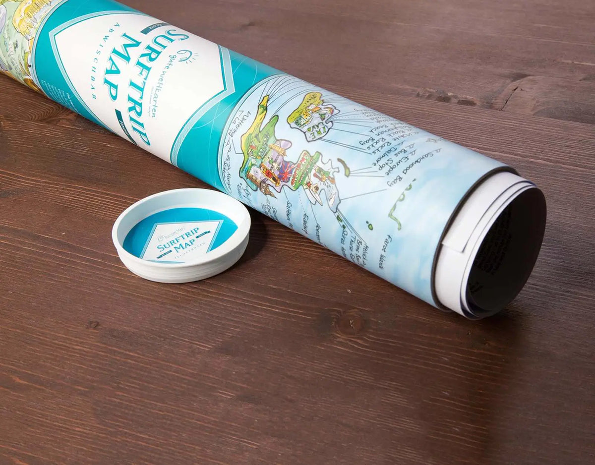 Tubo cilíndrico decorativo del mapa de surf Surftrip Map abierto sobre una mesa de madera