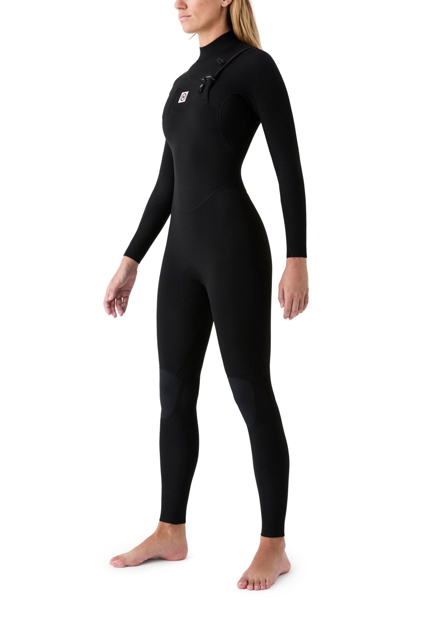 Vista lateral de una surfista usando el neopreno, resaltando el diseño de las mangas para una remada sin restricciones.