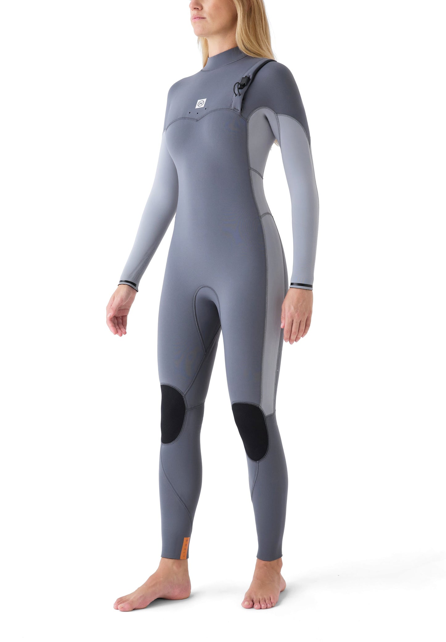 Vista lateral de una surfista con el traje Limitless III gris, resaltando la flexibilidad del neopreno en las articulaciones.