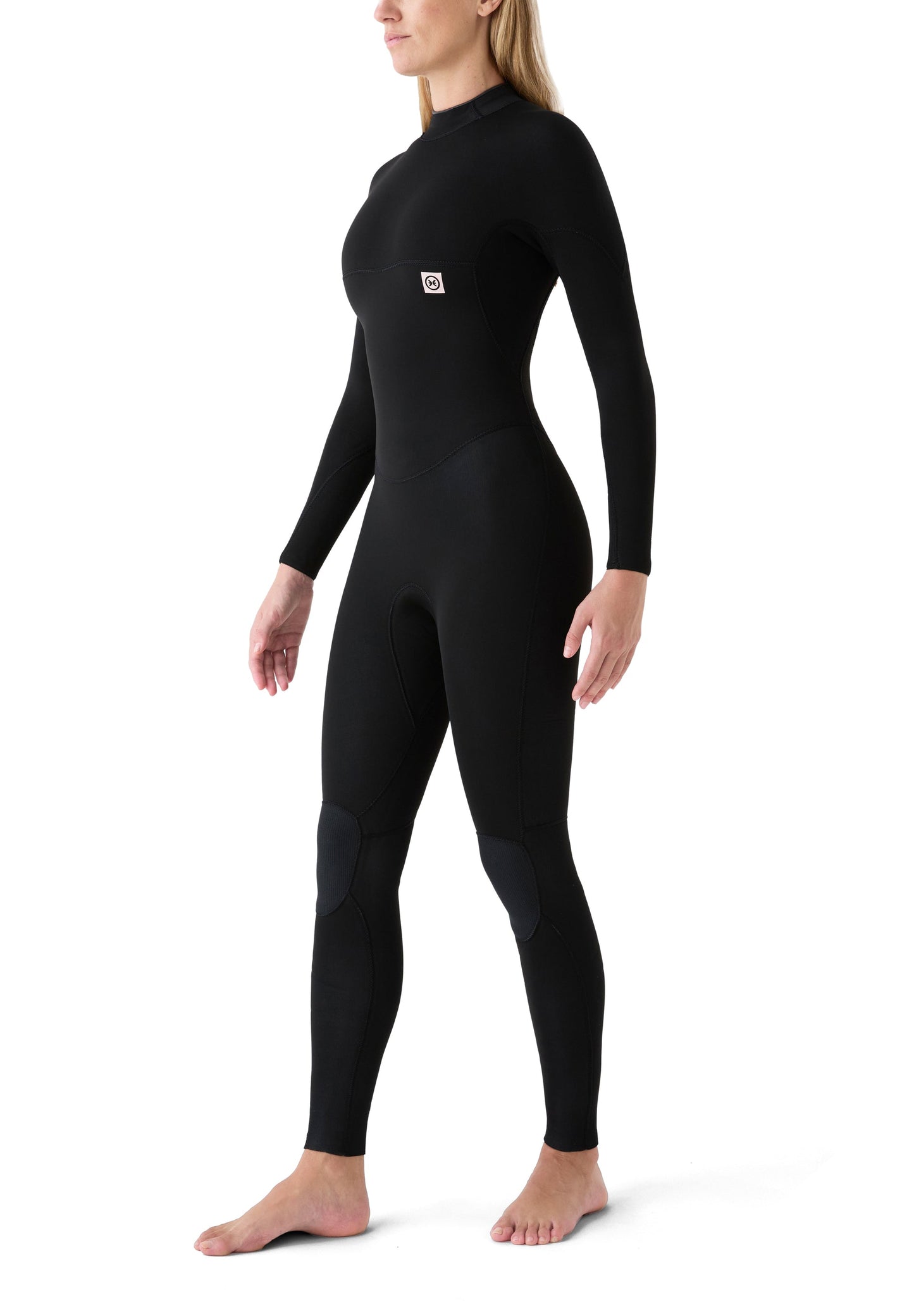 Vista lateral de una surfista con el traje 4/3, resaltando el ajuste anatómico que facilita la flexibilidad en brazos y piernas.