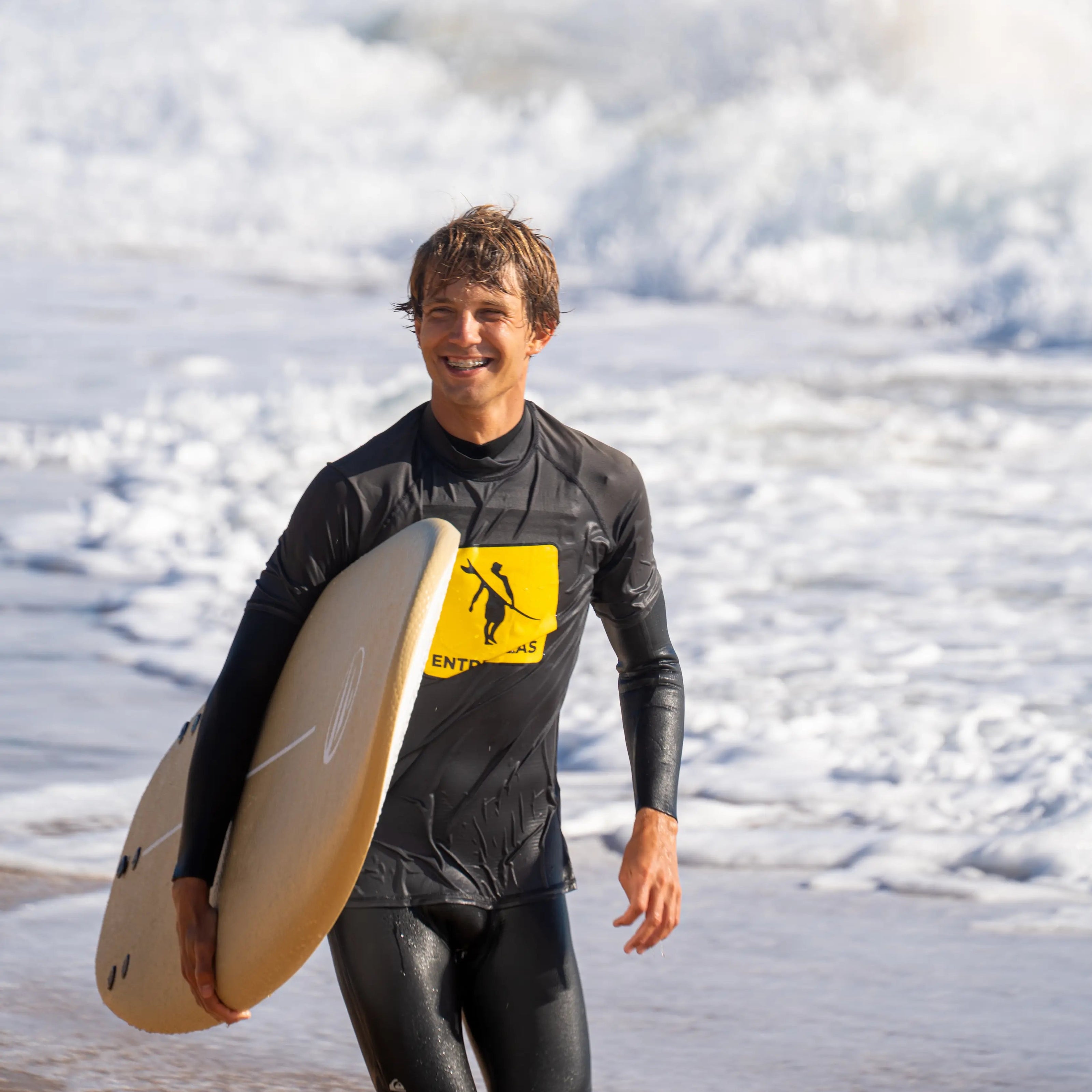 Fotografía de Nico llevando su tabla de surf amrilla de flysurf