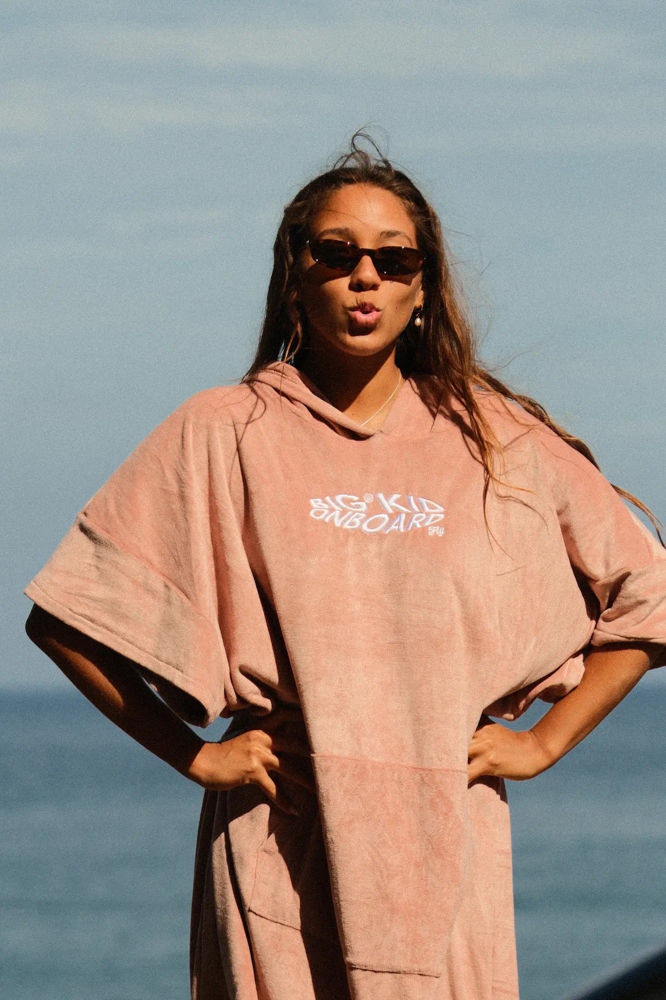 Guida con el poncho rosa en la playa de madeira